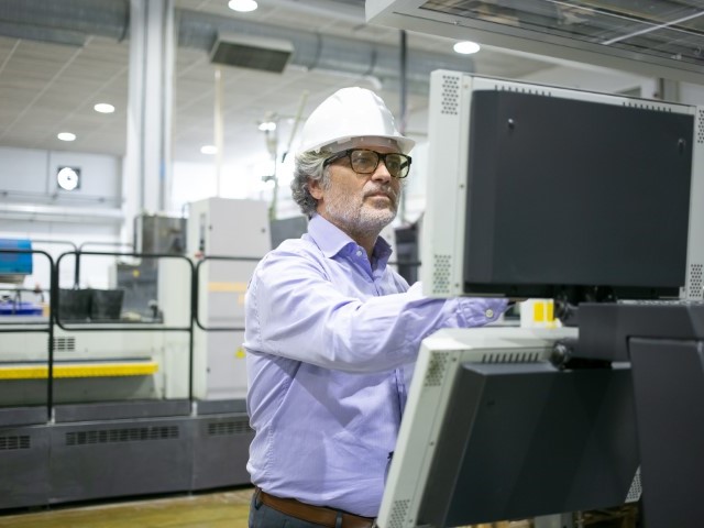 homme travaille sur une machine dans une usine